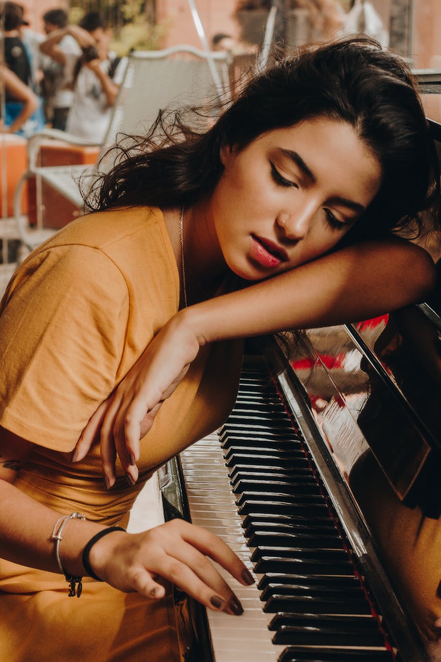 woman lying her head on piano